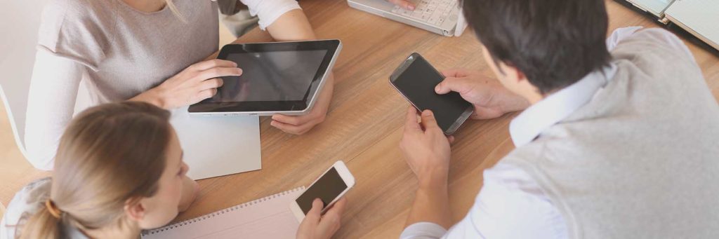 A group of people who are all looking at devices