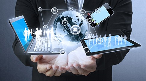 man holding a laptop and tablet with a network of people coming out of it