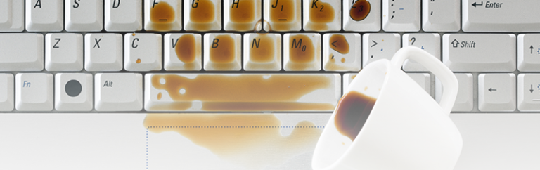 cup of coffee spilling on a keyboard