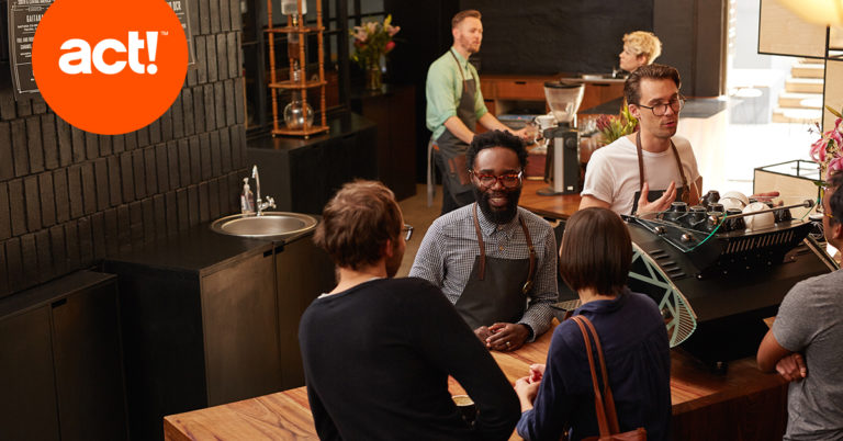 A groupe of people ina dim cafe with an act logo on the top left
