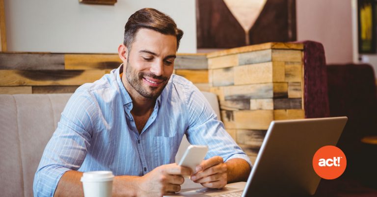 man working on a laptop with the act! Crm logo